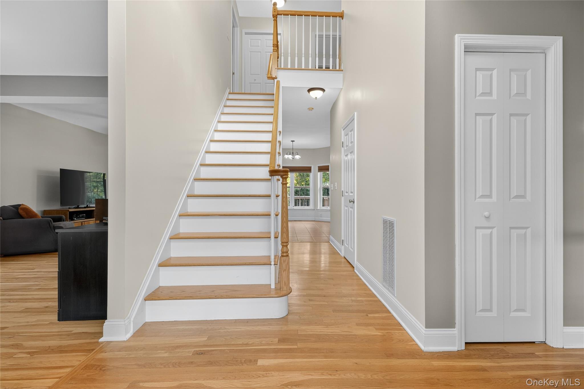 9 Exeter Circle Beacon, NY 12508 - Photo 5 of 41 a view of a hallway to a livingroom with wooden floor and stairs