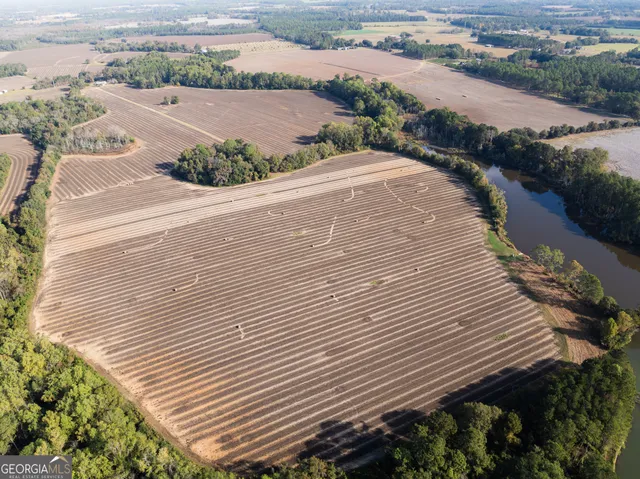 an aerial view of a house with a yard and mountain view in back