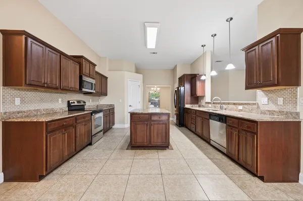 a kitchen with stainless steel appliances granite countertop a sink stove and microwave