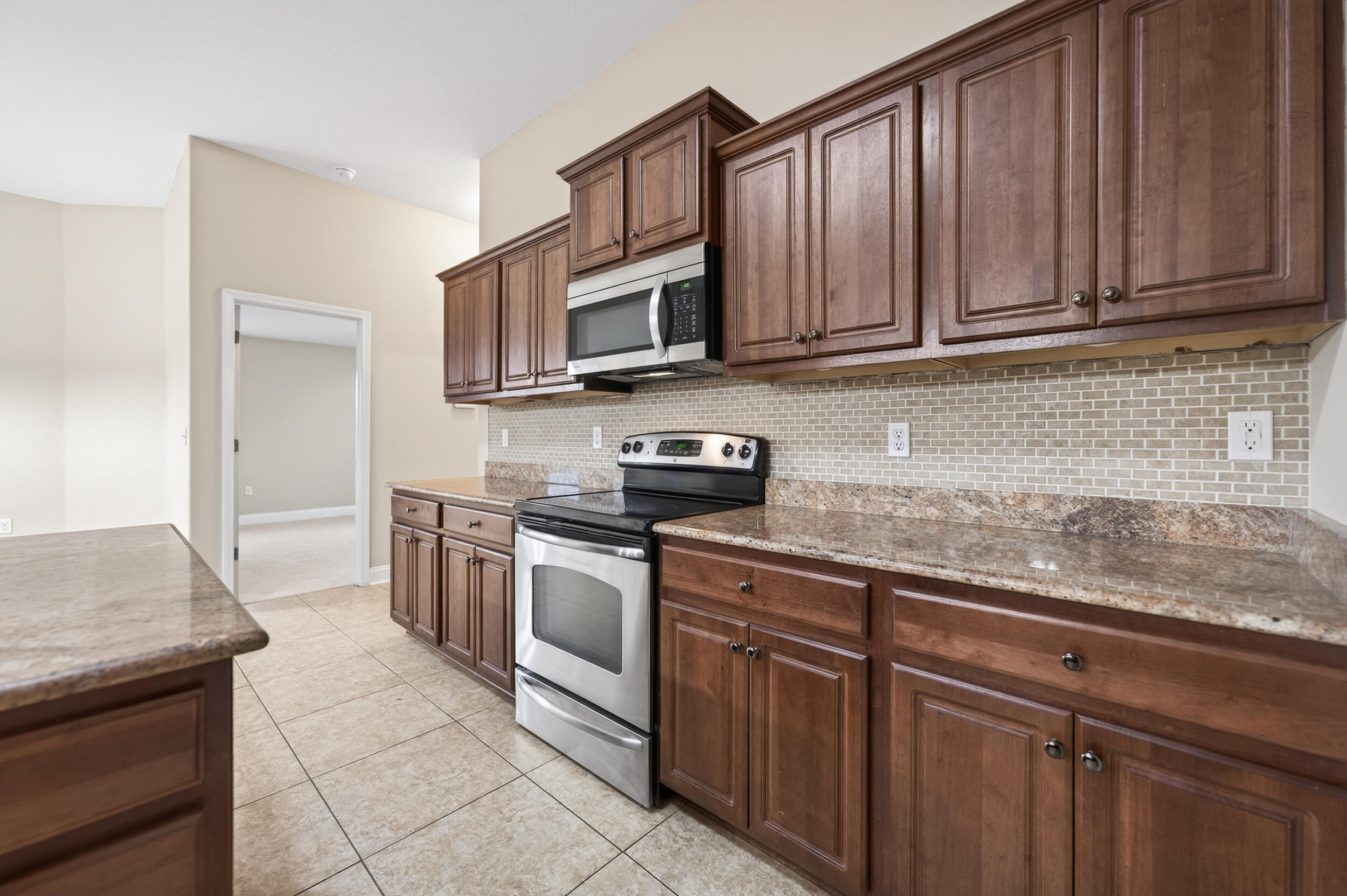 6210 Lapis Lane Crestview, FL 32539 - Photo 19 of 72 a kitchen with stainless steel appliances granite countertop a sink stove and microwave