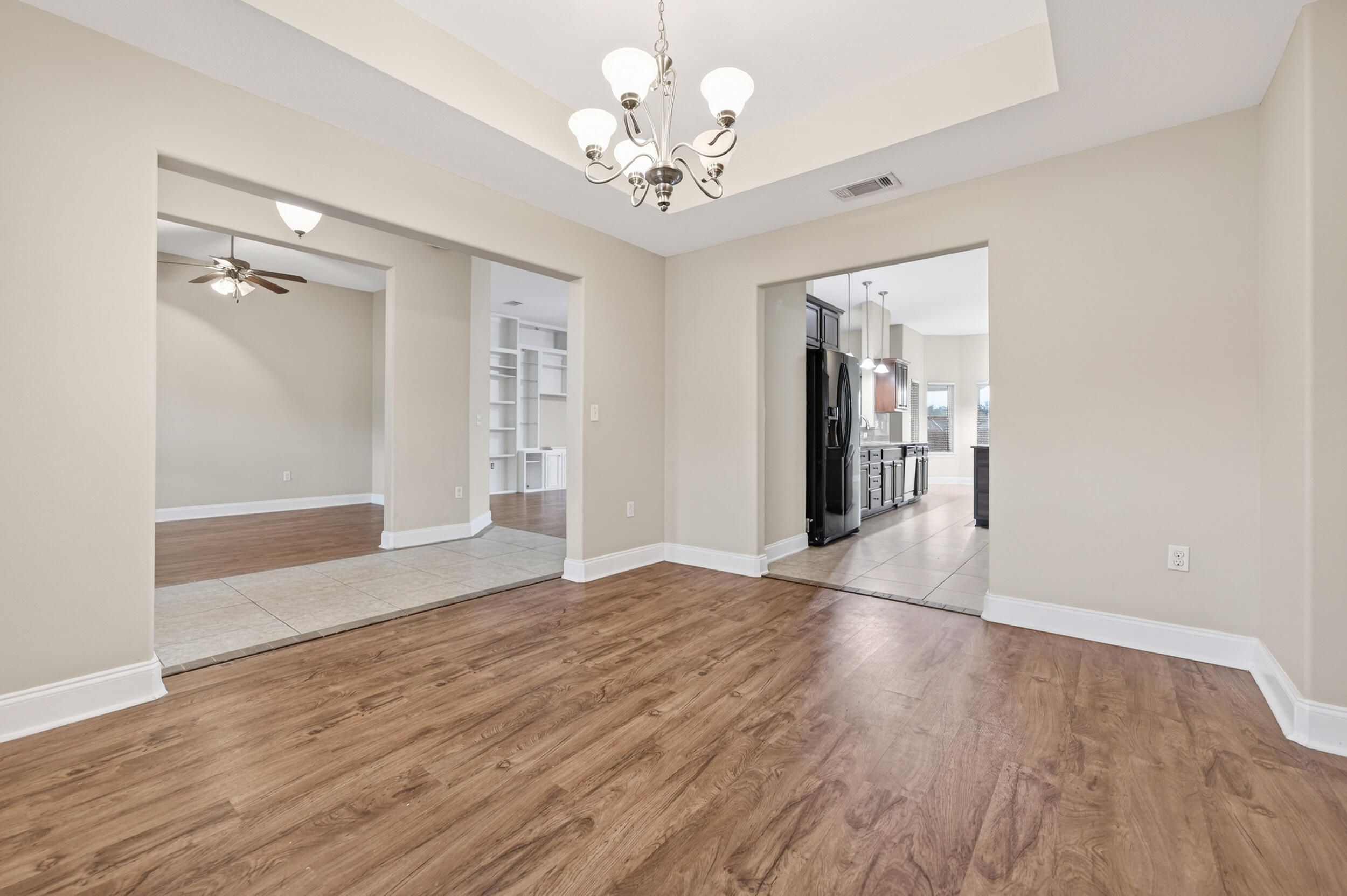 6210 Lapis Lane Crestview, FL 32539 - Photo 22 of 72 a view of an empty room with wooden floor and a chandelier