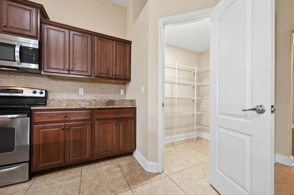 a spacious bathroom with a granite countertop sink two mirror and bathtub