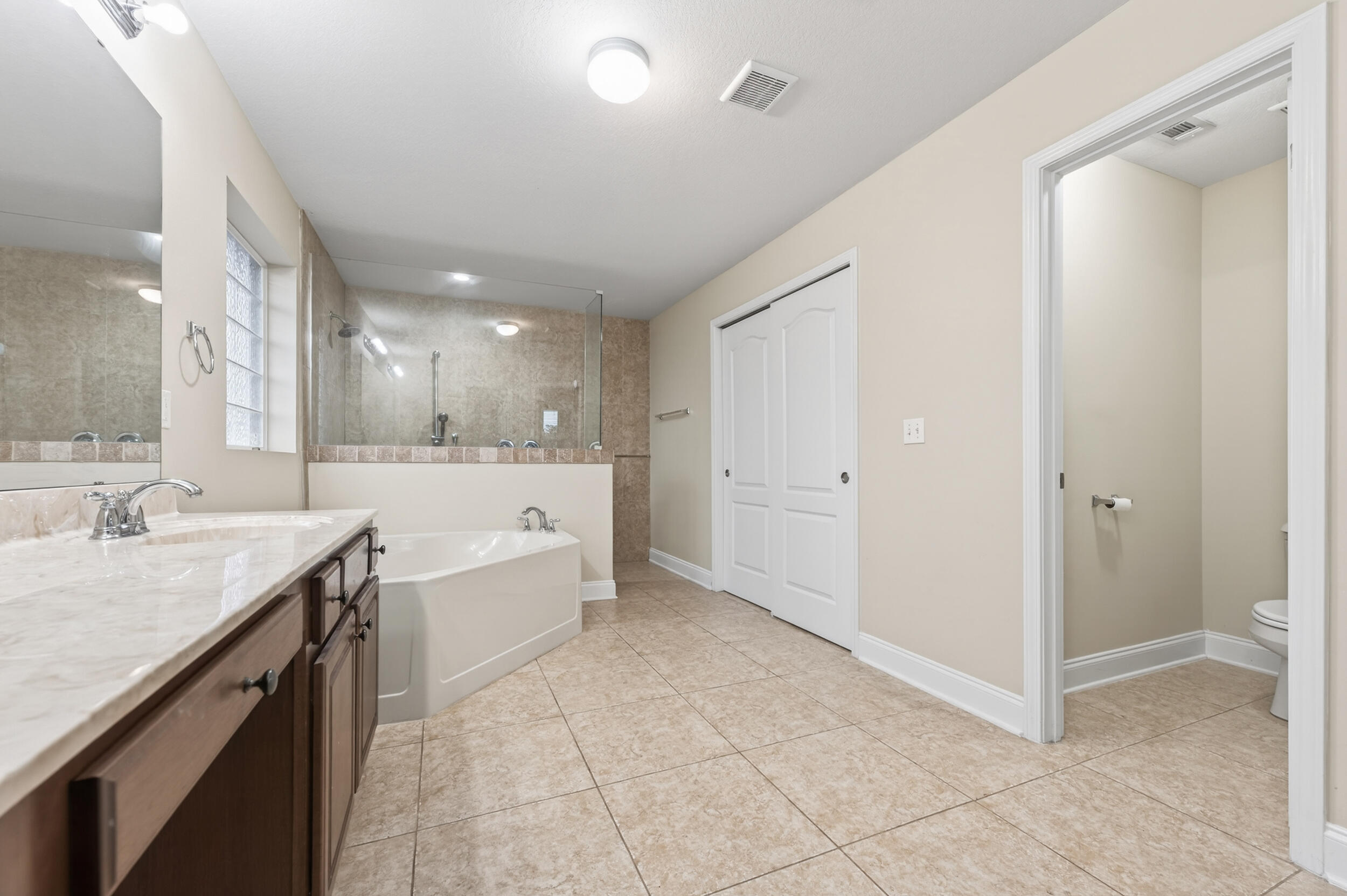 6210 Lapis Lane Crestview, FL 32539 - Photo 35 of 72 a large bathroom with a granite countertop sink a toilet a mirror and a tub
