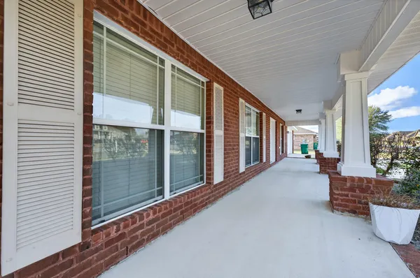 a view of a hallway with wooden floor and a bathroom