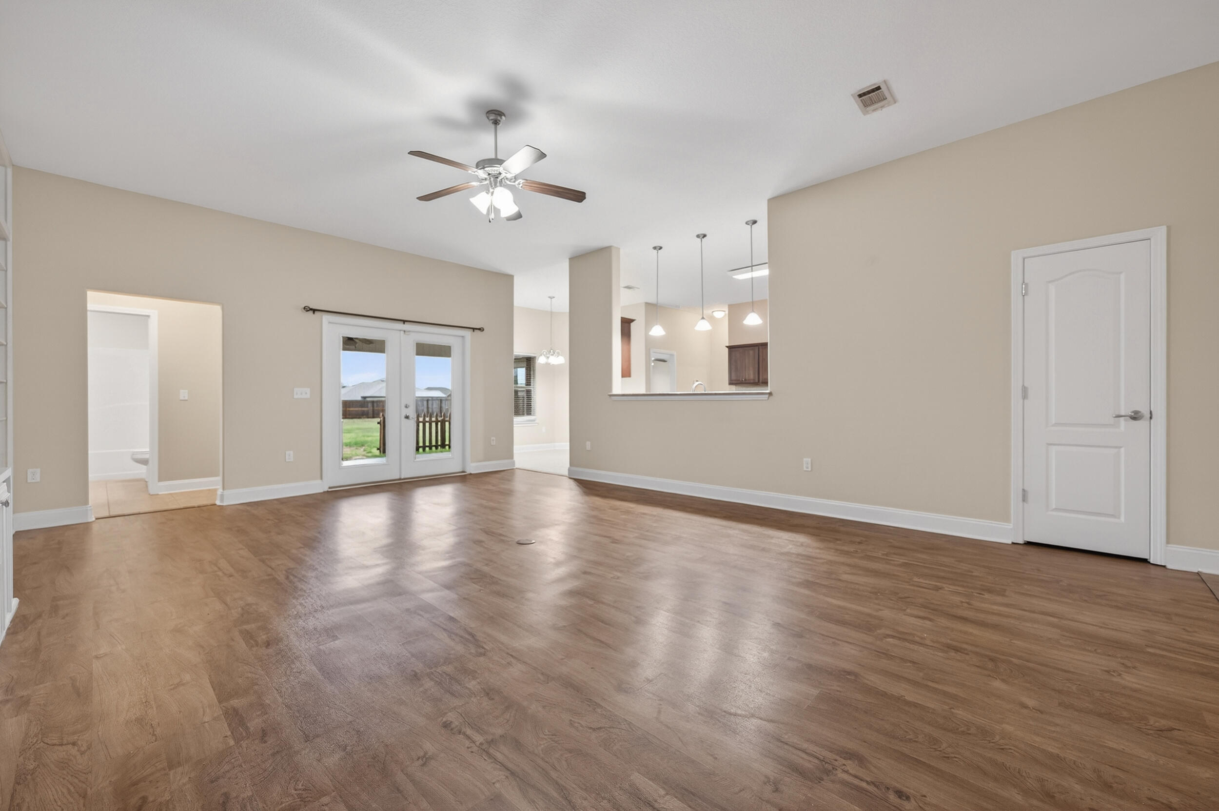 6210 Lapis Lane Crestview, FL 32539 - Photo 10 of 72 a view of an empty room with wooden floor and a window