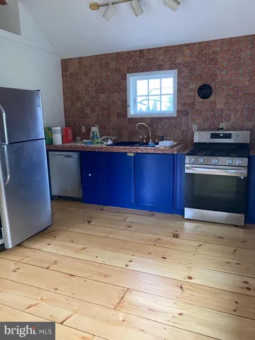 a view of kitchen with stainless steel appliances granite countertop cabinets and window