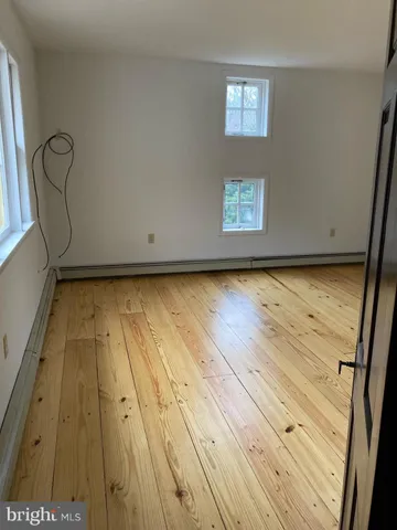 a view of a room with wooden floor and window