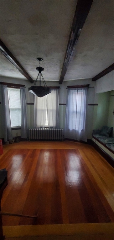 44 Clark Street, Unit 44 Lynn, MA 01902 - Photo 4 of 10 an empty room with wooden floor and windows