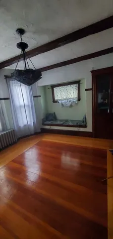 a view of a room with wooden floor and a ceiling fan
