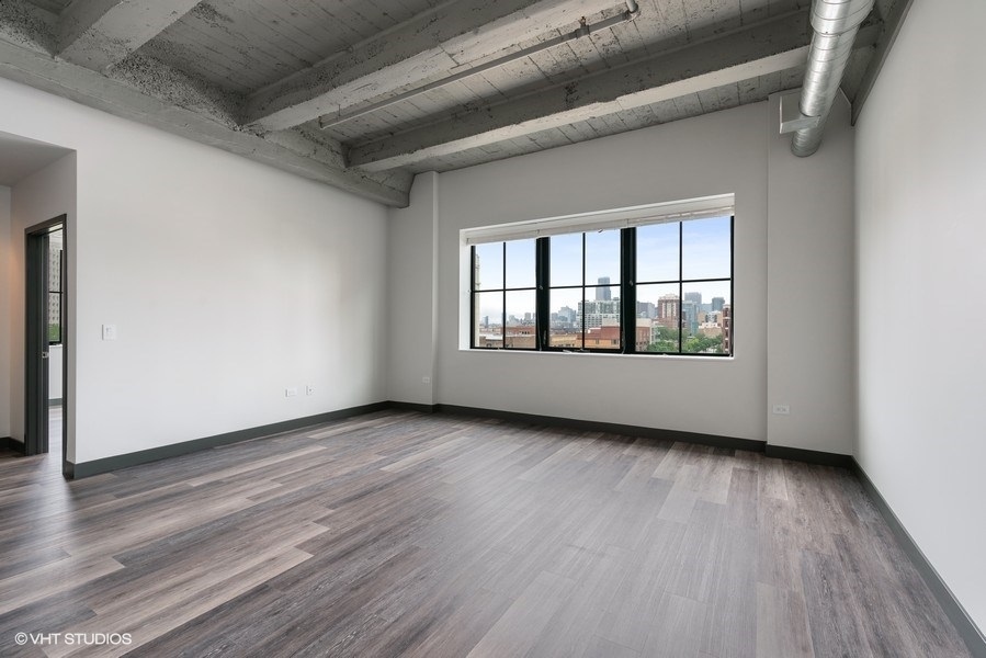 2101 South Wabash Avenue, Unit 402 Chicago, IL 60616 - Photo 2 of 9 an empty room with wooden floor and windows