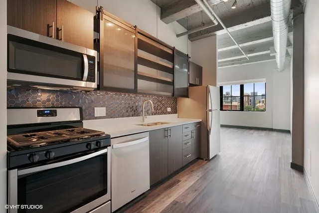 a kitchen with stainless steel appliances kitchen island granite countertop a stove and a microwave