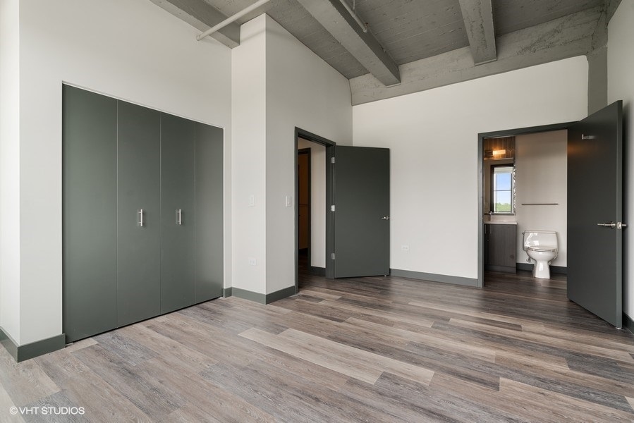 2101 South Wabash Avenue, Unit 402 Chicago, IL 60616 - Photo 6 of 9 a view of an empty room with wooden floor and a bathroom