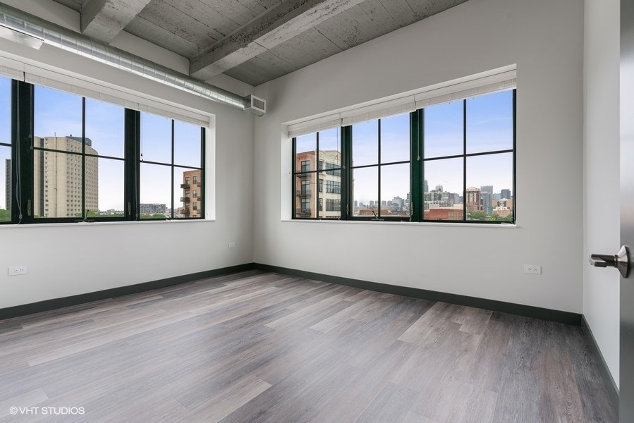 2101 South Wabash Avenue, Unit 402 Chicago, IL 60616 - Photo 8 of 9 a view of an empty room with a window and wooden floor