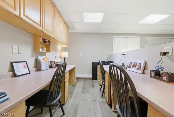 a living room with furniture and a dining area with wooden floor