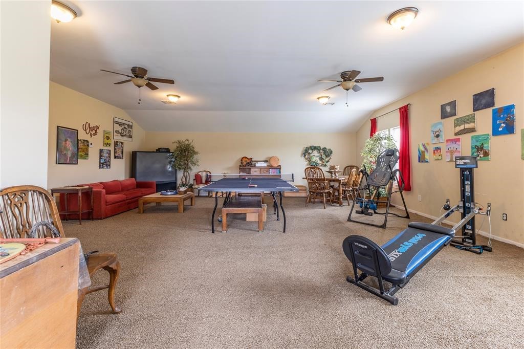 8456 Schuster Road Ledbetter, TX 78946 - Photo 42 of 49 a living room with furniture gym equipment and a chandelier