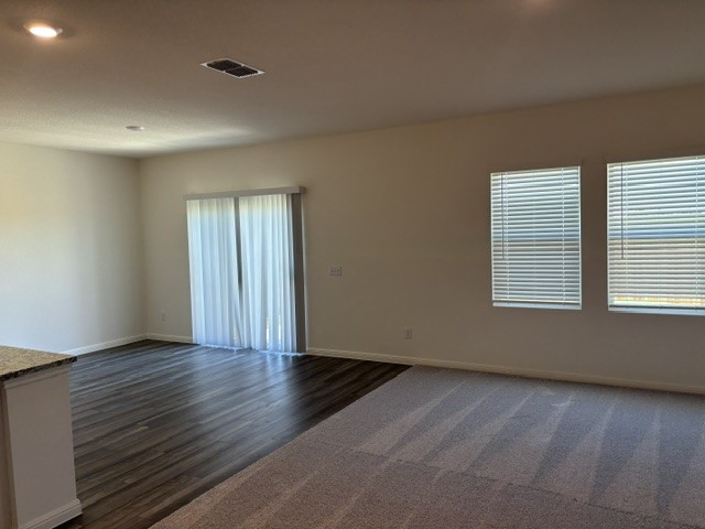 702 Gemsbok Road Hutto, TX 78634 - Photo 5 of 9 a view of an empty room with wooden floor and a window