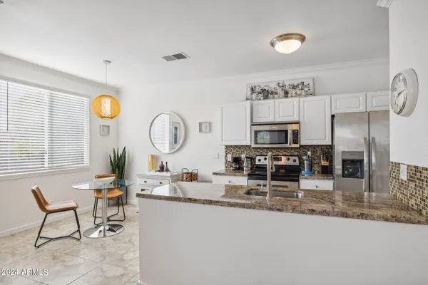 a very nice looking kitchen with a dining table and a refrigerator