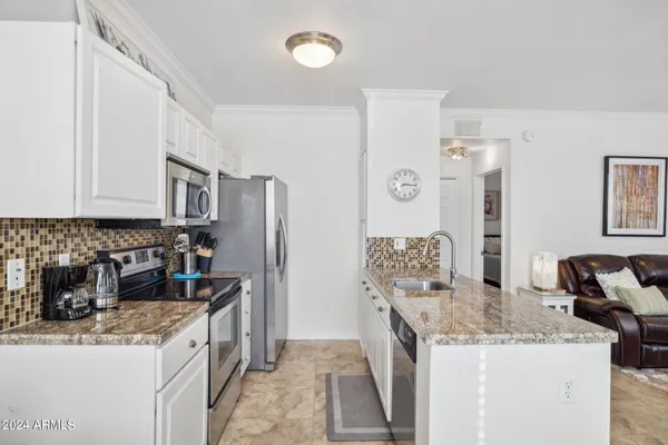 a kitchen with stainless steel appliances granite countertop a sink stove and refrigerator