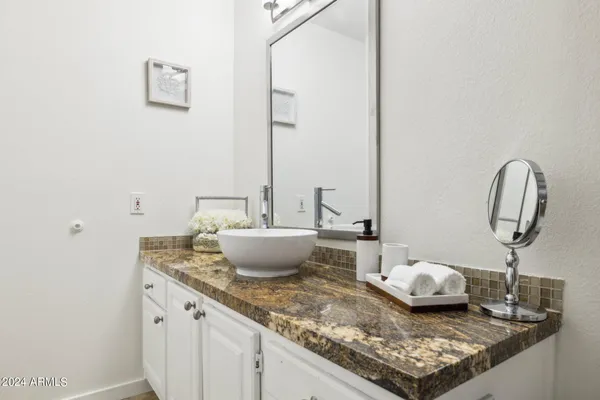 a bathroom with a granite countertop toilet sink and mirror