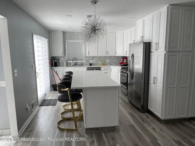 a kitchen with kitchen island a counter top space a sink stainless steel appliances and cabinets