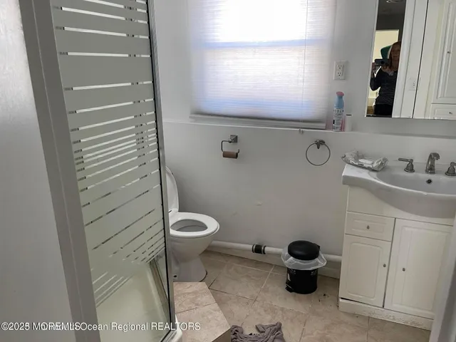 a bathroom with a sink toilet and window