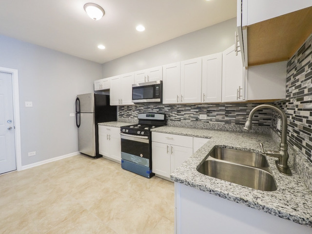 6849 South Green Street, Unit 1 Chicago, IL 60621 - Photo 2 of 4 a kitchen with stainless steel appliances granite countertop a sink stove and refrigerator