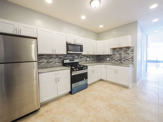 6849 South Green Street, Unit 1 Chicago, IL 60621 - Photo 3 of 4 a kitchen with stainless steel appliances granite countertop a refrigerator a stove a sink and a microwave