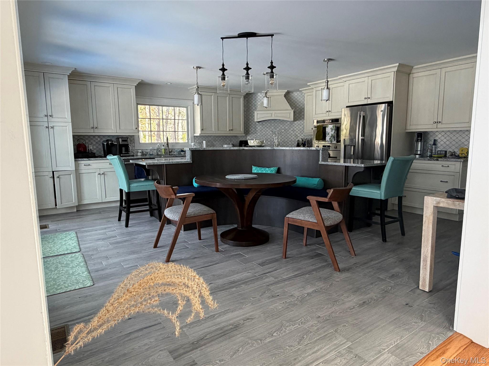 27 Deer Path Quogue, NY 11959 - Photo 12 of 44 a living room with stainless steel appliances kitchen island granite countertop furniture wooden floor and a window