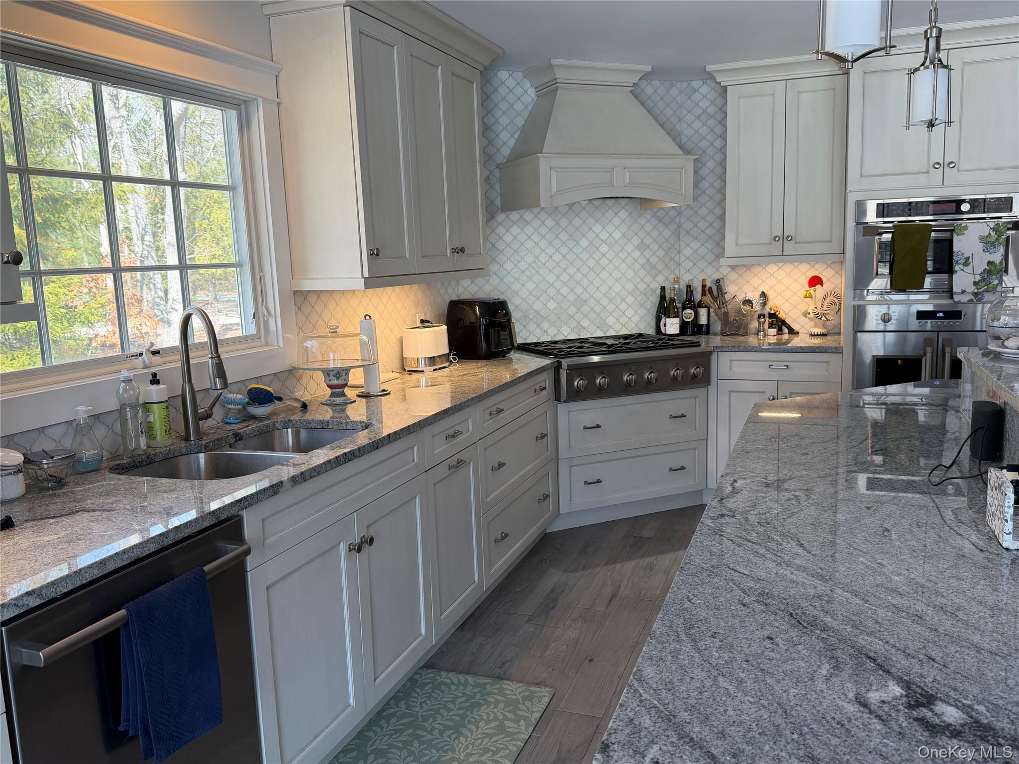 27 Deer Path Quogue, NY 11959 - Photo 15 of 44 a kitchen with stainless steel appliances granite countertop a sink a stove and a granite counter tops