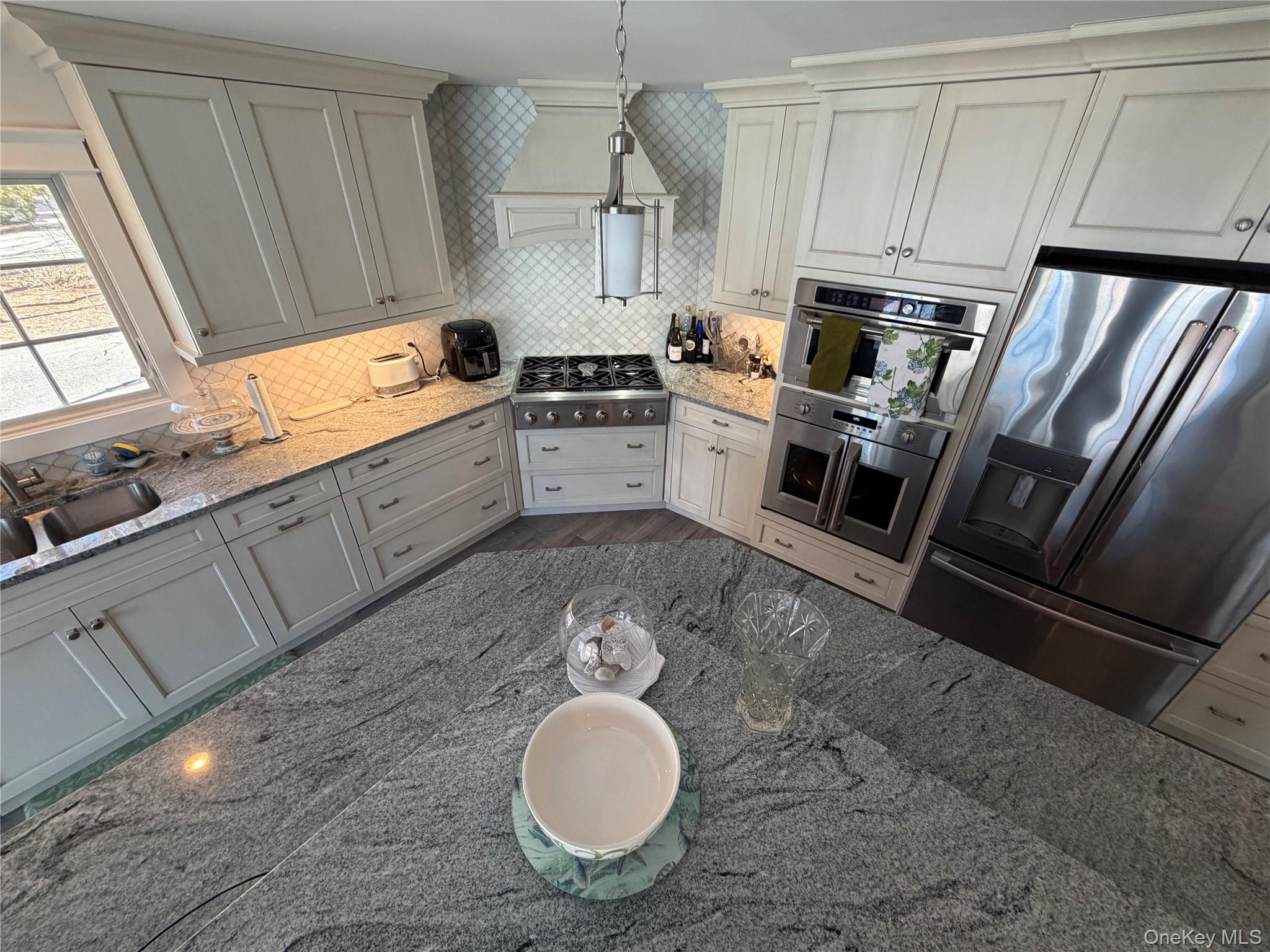 27 Deer Path Quogue, NY 11959 - Photo 16 of 44 a kitchen with sink refrigerator and stove