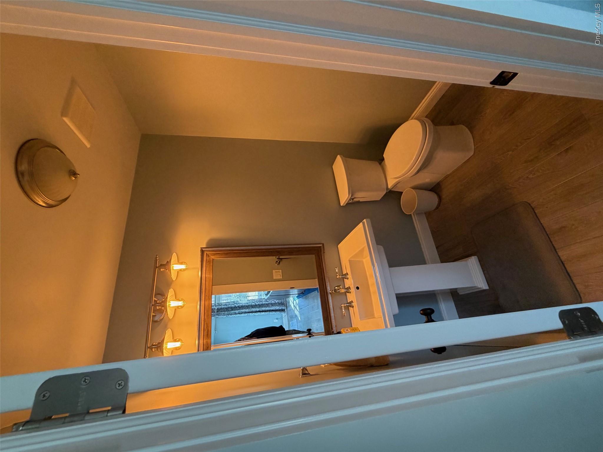 27 Deer Path Quogue, NY 11959 - Photo 19 of 44 a bathroom with a sink and a mirror