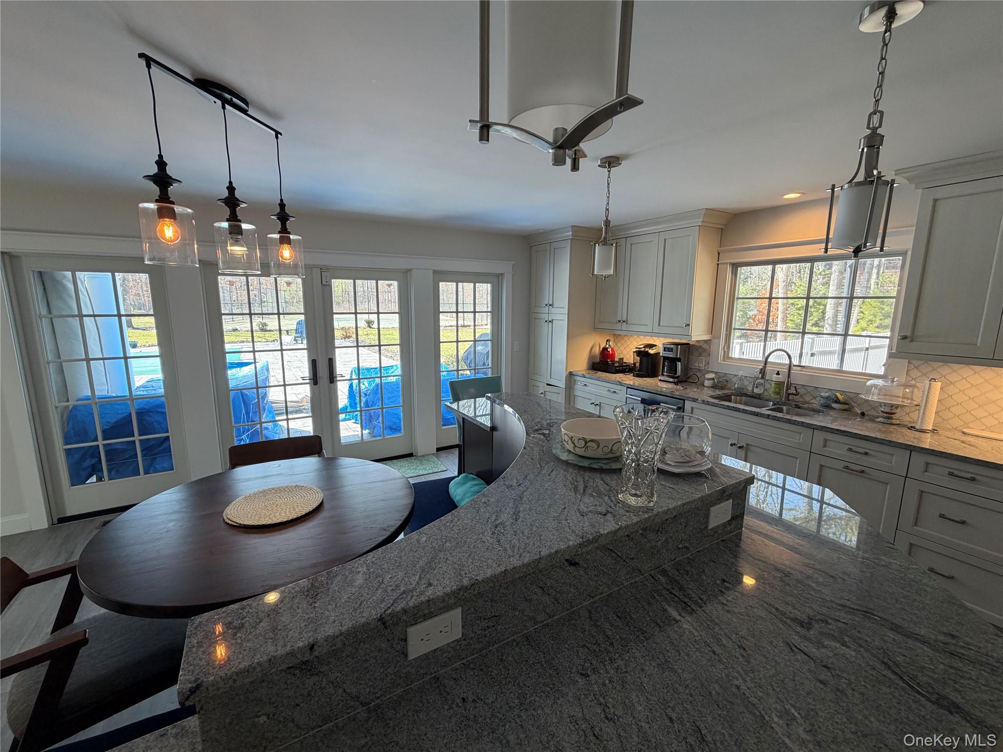 27 Deer Path Quogue, NY 11959 - Photo 21 of 44 a kitchen with sink dining table and chairs