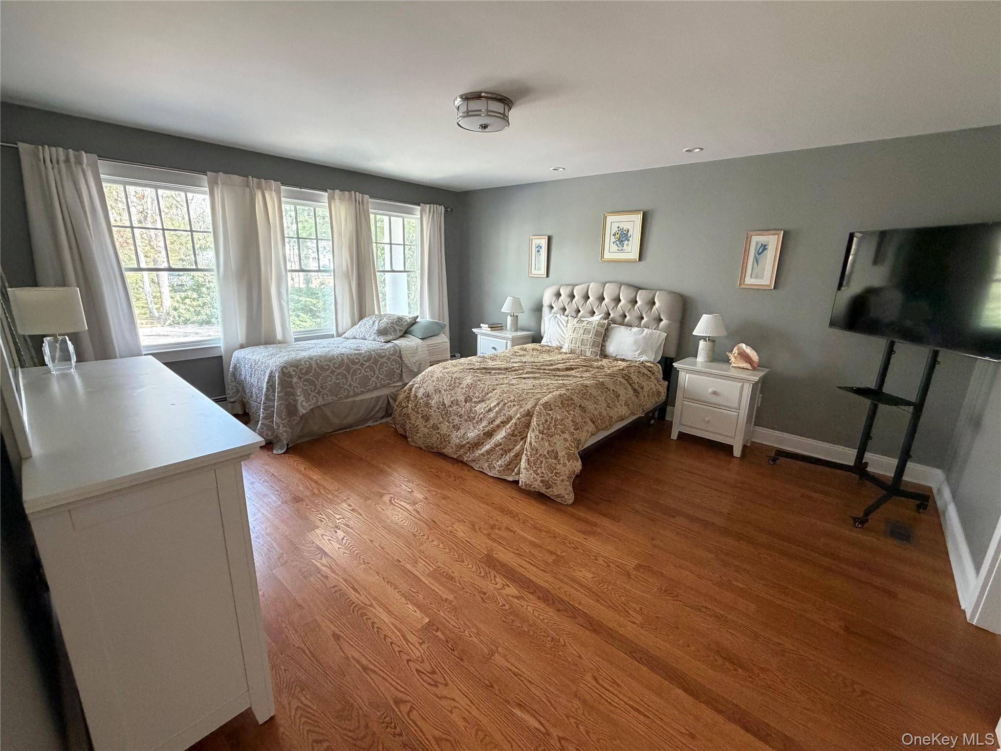 27 Deer Path Quogue, NY 11959 - Photo 22 of 44 a bedroom with a bed and wooden floor