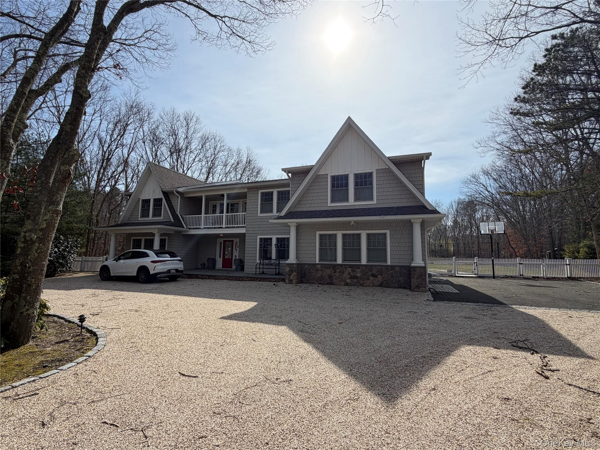 27 Deer Path Quogue, NY 11959 - Photo 33 of 44 a front view of a house with a yard covered in snow