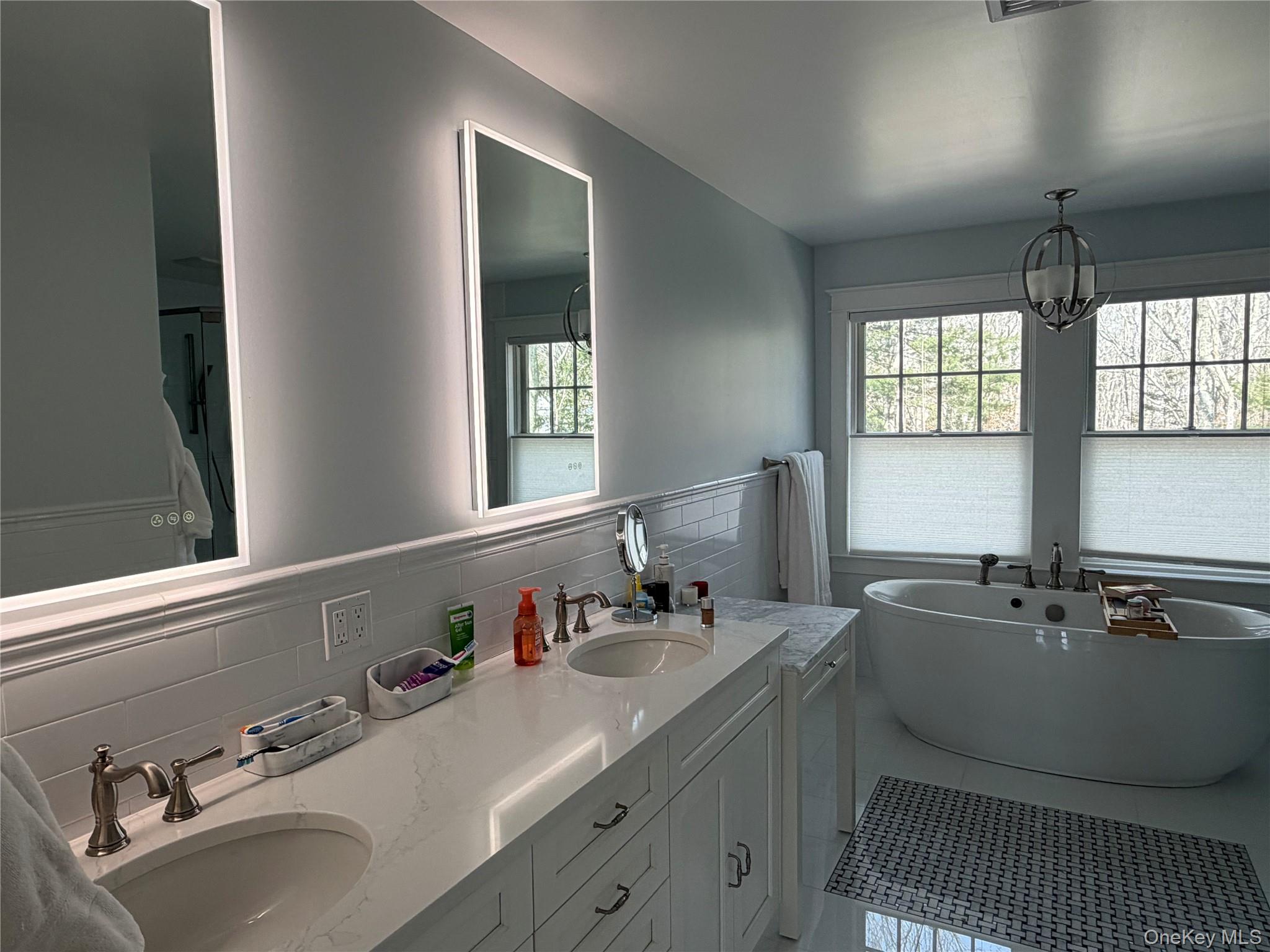 27 Deer Path Quogue, NY 11959 - Photo 38 of 44 a bathroom with a sink and a mirror