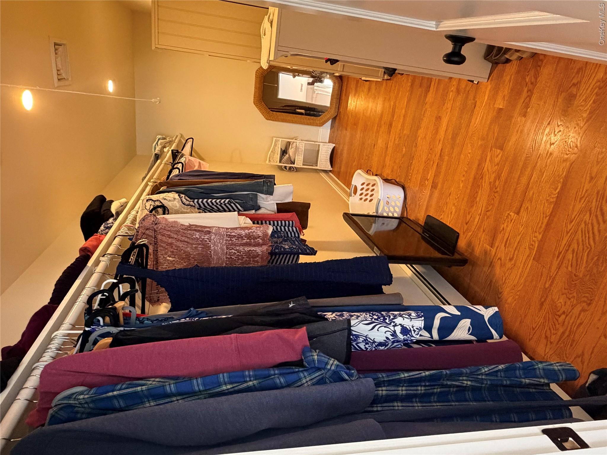 27 Deer Path Quogue, NY 11959 - Photo 41 of 44 a view of walk in closet with clothes and shoes