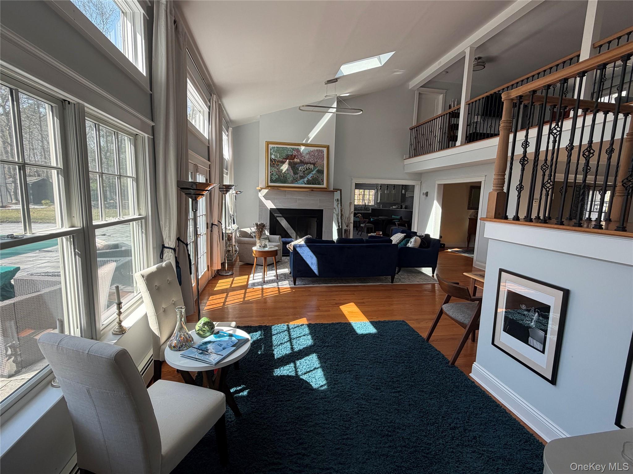 27 Deer Path Quogue, NY 11959 - Photo 10 of 44 a living room with furniture a fireplace and a large window