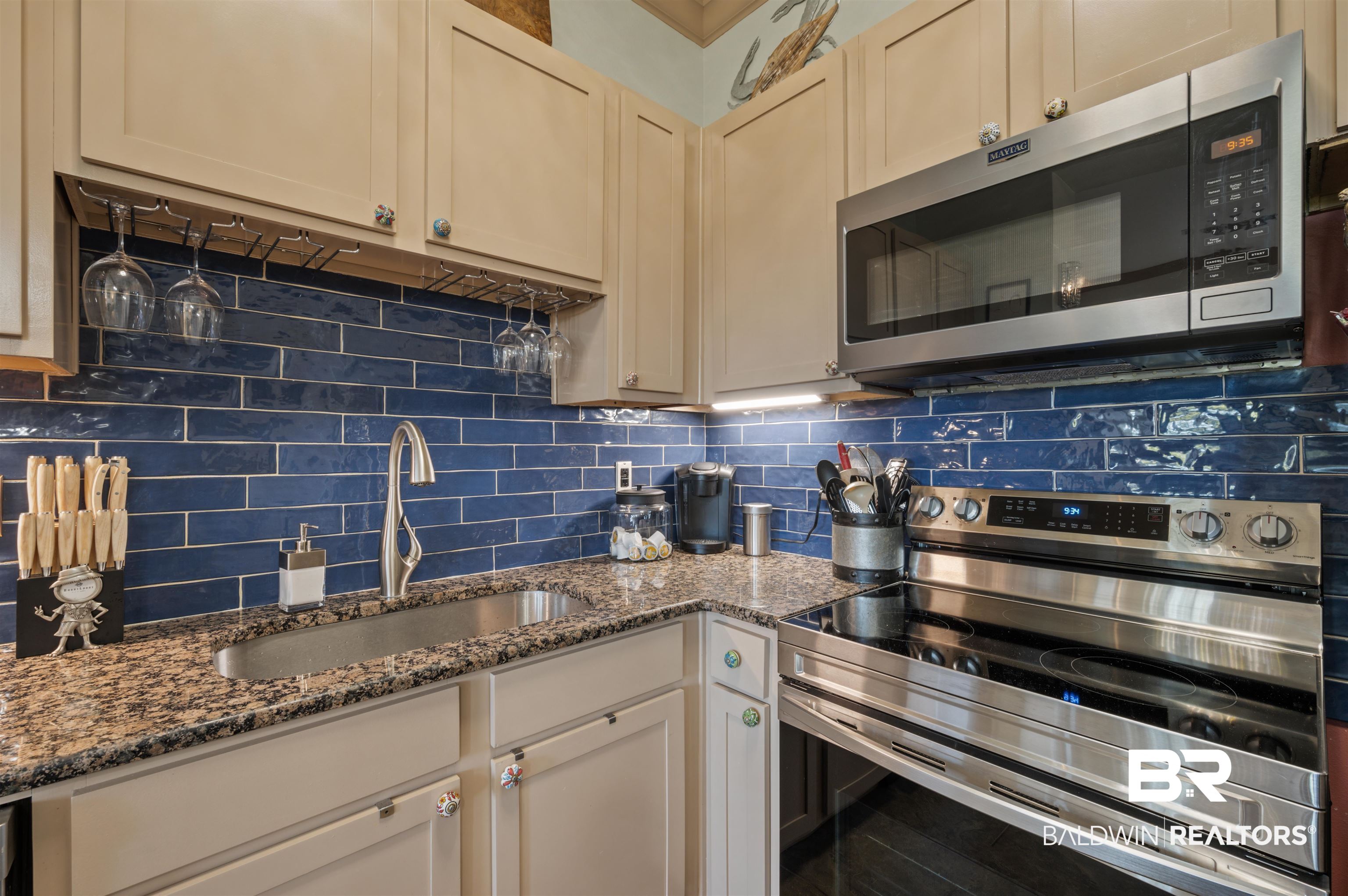 1430 Regency Road, Unit B202 Gulf Shores, AL 36542 - Photo 5 of 33 Kitchen with appliances with stainless steel finishes, backsplash, a sink, and dark stone counters