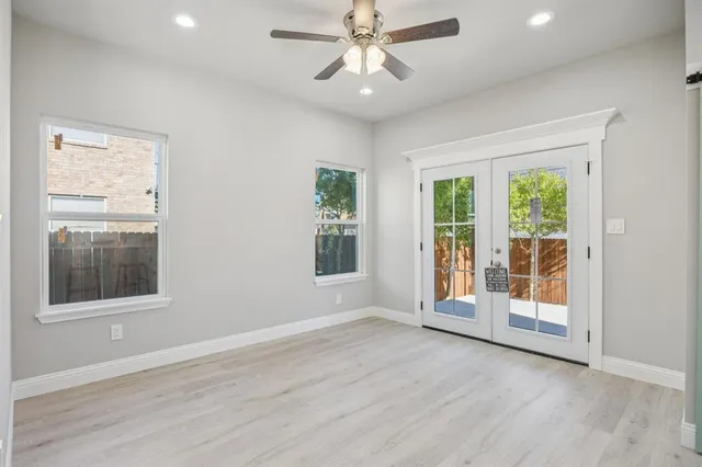 a view of an empty room with a window and wooden floor