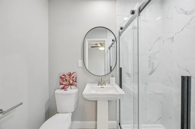 a bathroom with a toilet sink and mirror