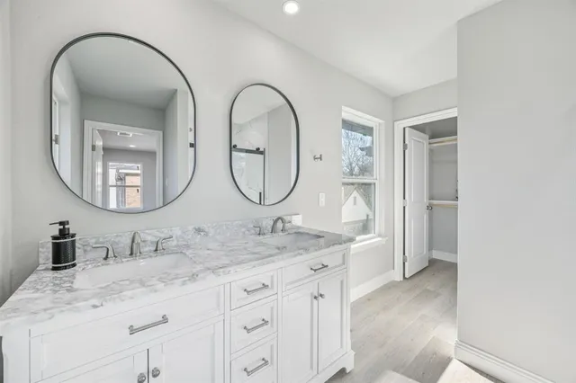 a bathroom with a granite countertop double vanity sink and a mirror