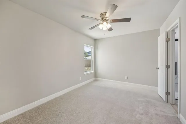 a view of an empty room with chandelier fan