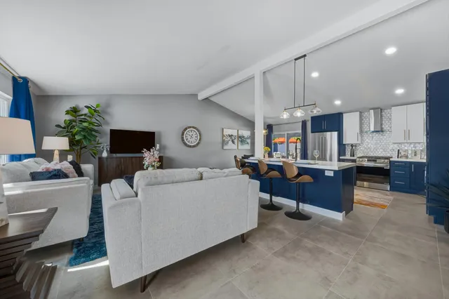 a living room with furniture and kitchen view