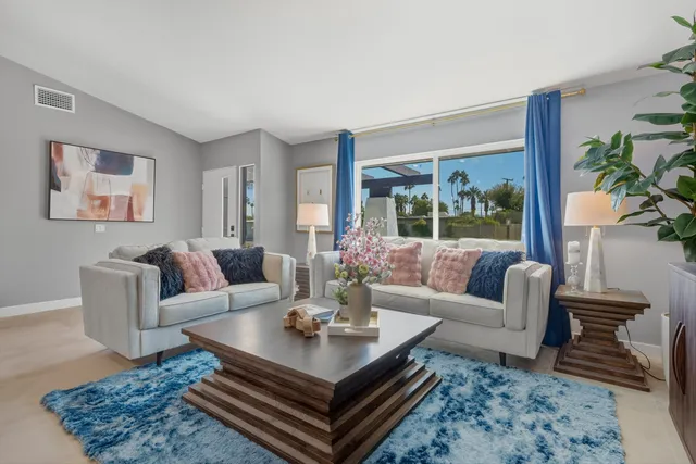 a living room with furniture a table and a large window