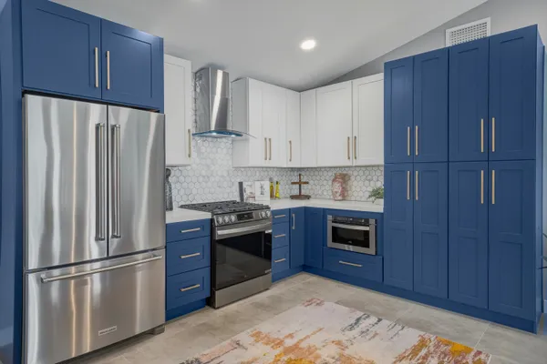 a kitchen with stainless steel appliances granite countertop a refrigerator stove and wooden cabinets