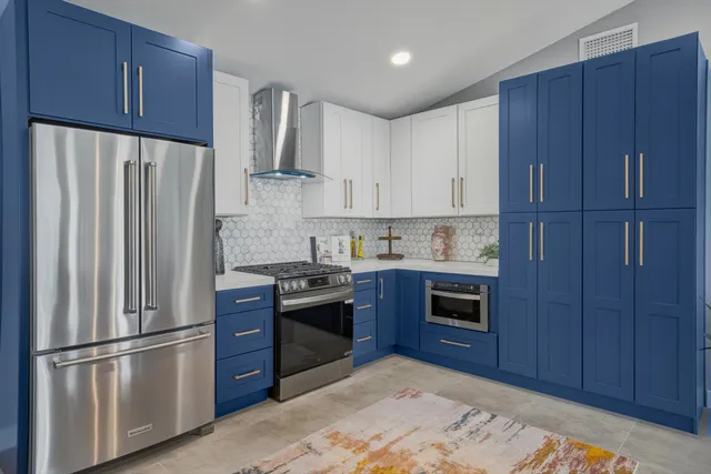 a kitchen with stainless steel appliances granite countertop a refrigerator stove and wooden cabinets