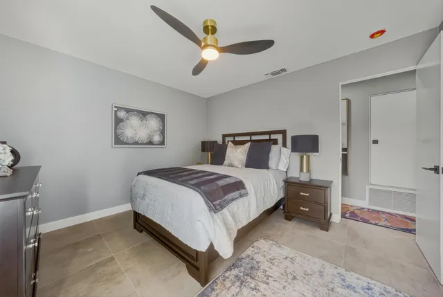 a bedroom with a bed and a ceiling fan
