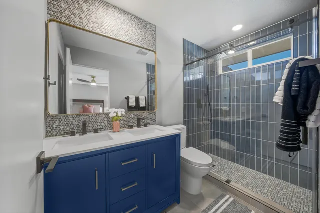 a bathroom with a sink a toilet and shower