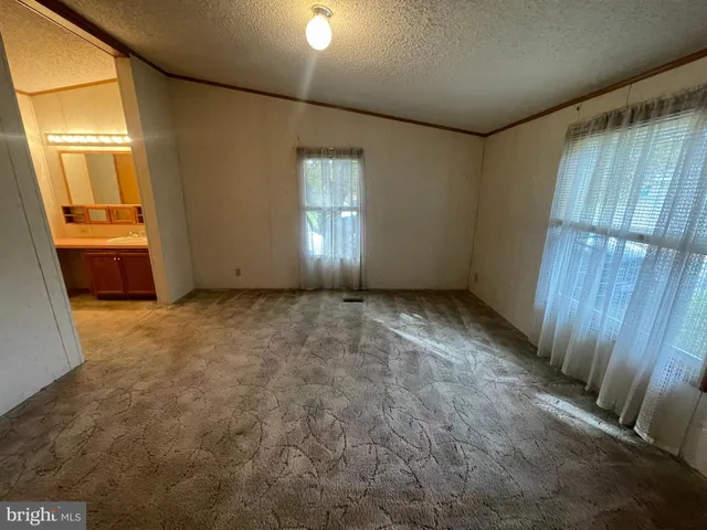 a view of an empty room with a fireplace and a window