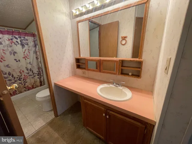 a bathroom with a sink vanity granite and a mirror